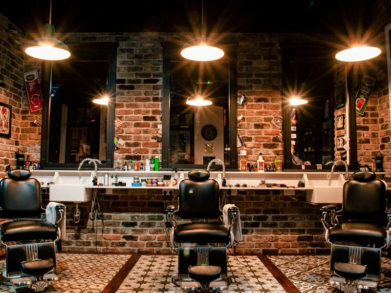 Interior view of A-Plus Gents grooming salon with vintage styling chairs and ambient mirror lighting.